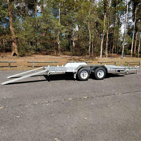 Thematic photo of a two-axle car trailer with a tipping function loaded with bulk material