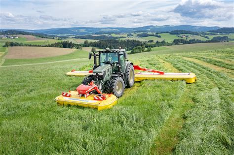 Thematic photo of a Pöttinger front mower at work in a field
