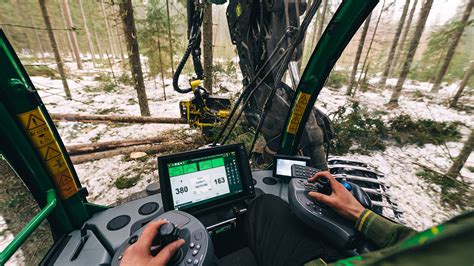zdjęcie harvestera John Deere pracującego w lesie z głowicą ścinkową