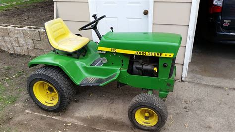 Thematic photo of a John Deere 120 Automatic lawn tractor in a garden