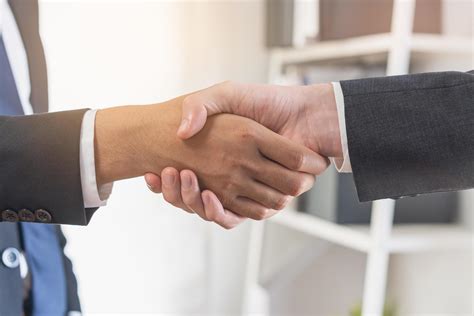 Photo showing a satisfied customer shaking hands with a service provider, illustrating good client-contractor relations.