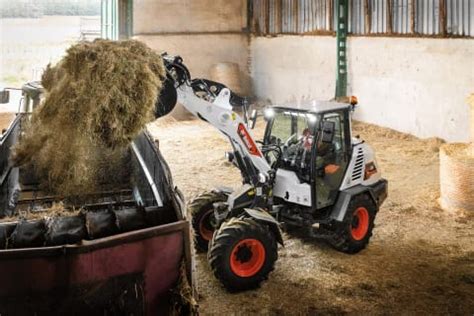 Zdjęcie ładowarki kołowej Bobcat L95 pracującej w gospodarstwie rolnym.