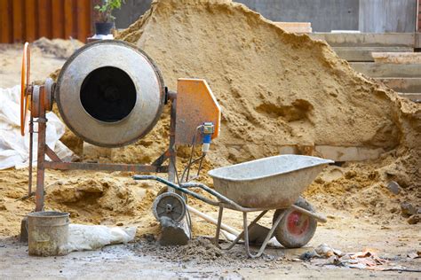 Thematic photo of a construction site with a concrete mixer in the foreground