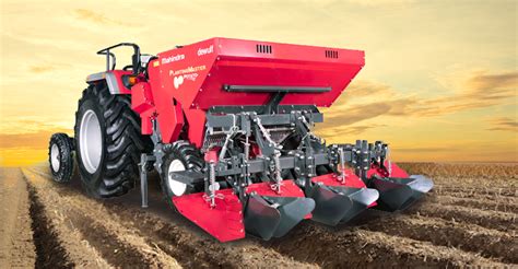 Thematic photo of a 4-row potato planter with a hydraulic bunker working in a field