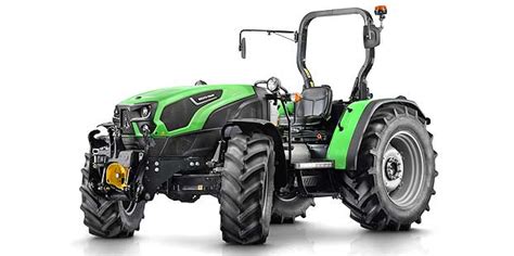 The Deutz-Fahr 5TB series tractor in an agricultural field, showing its compact design and safety frame instead of a cabin. The image should emphasize its stability on slightly uneven terrain.