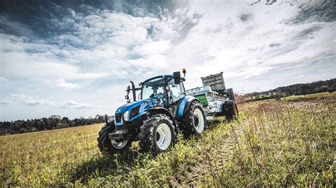 Historyczne zdjęcie ciągnika New Holland serii TM w trakcie prac polowych