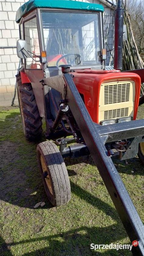 Ciągnik z kabiną w akcji, wykonujący prace polowe