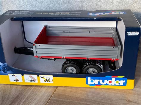 Zdjęcie przedstawiające srebrną przyczepę Bruder 02019 w skali 1:16 z widocznymi detalami konstrukcyjnymi
