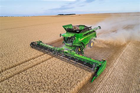 Kombajn John Deere X9 1100 z hederem podczas pracy w polu