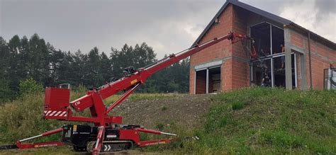 Mini żuraw budowlany pracujący wewnątrz budynku podczas montażu wielkogabarytowych szyb