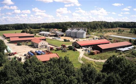 Sielski widok na wirtualne gospodarstwo z nowoczesnym traktorem i podczepionym pługiem