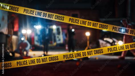 Photo of police car and officers investigating a crime scene