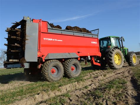 Tematyczne zdjęcie rozrzutnika Unia Tytan 8 pracującego na polu