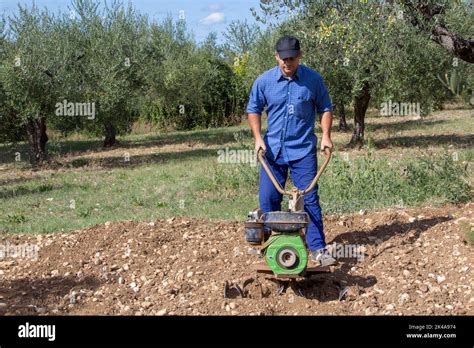 Thematic photo of a person working with a rotary tiller in a garden