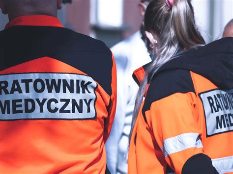 Ratownicy medyczni udzielający pomocy poszkodowanemu rolnikowi na polu