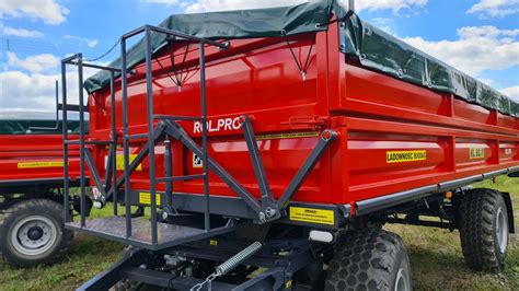 Zdjęcie przedstawiające różne typy przyczep rolniczych: od małych jednosiowych po duże dwuosiowe wywrotki.