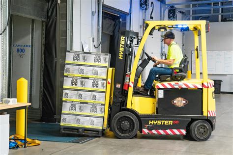 Technik serwisujący wózek widłowy, sprawdzający kluczowe komponenty dla bezpieczeństwa
