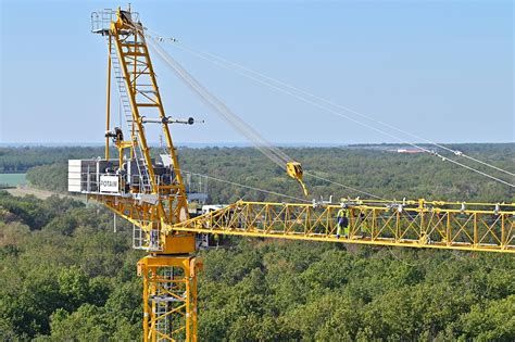 The Potain MDLT 1109 tower crane lifting heavy precast elements on a construction site, demonstrating its high capacity and precision.