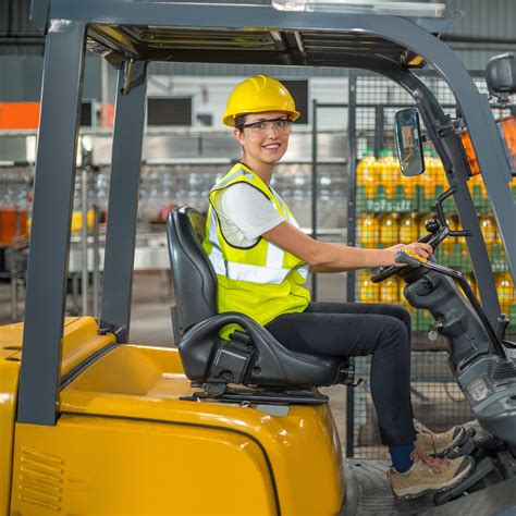 Thematic photo of a forklift operator wearing full PPE (helmet, gloves, safety shoes, high-visibility vest).