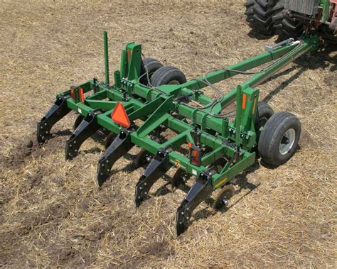 Thematic photo of a subsoiler (głębosz) working in a field, showing soil being broken up.