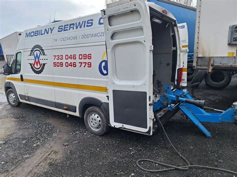 mobilny serwis JCB w akcji (furgonetka, mechanik przy maszynie)