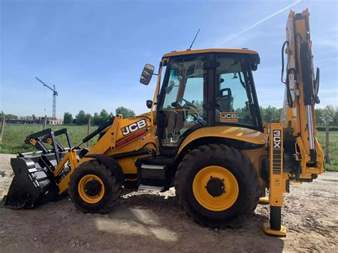 Zastosowanie koparko-ładowarki JCB 3CX w pracach budowlanych (zdjęcie koparki podczas kopania)