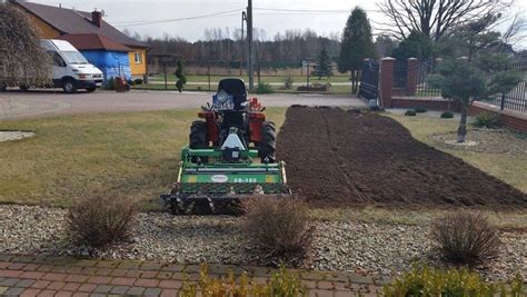 zdjęcie ogrodu z zadbanym trawnikiem i traktorkiem kosiarką