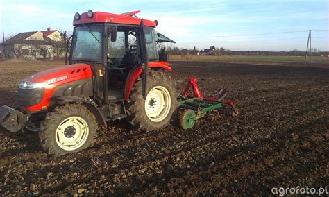 Zrzut ekranu z Farming Simulator 17 przedstawiający traktor z podłączonym kultywatorem podczas pracy na polu
