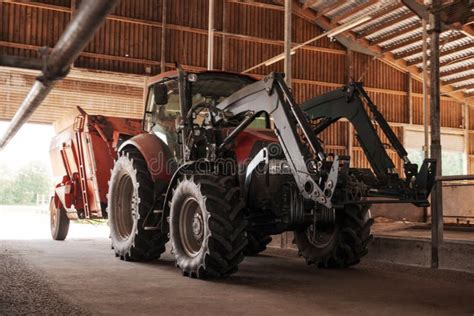Thematic photo of a modern farm with a tractor equipped with a front loader working