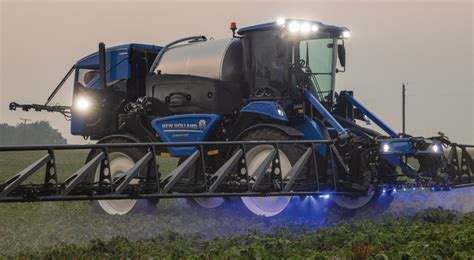 Opryskiwacz samojezdny New Holland w akcji na polu w Farming Simulator 15