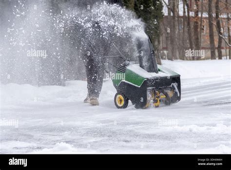 Thematic photo of a snow blower in action on a snowy driveway