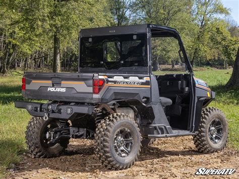 Thematic photo of a Polaris Ranger UTV working on a farm, pulling a small trailer or carrying tools.