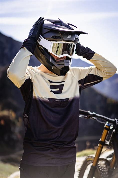 Rowerzysta DH w pełnym rynsztunku ochronnym: kask full-face, ochraniacze, rękawice