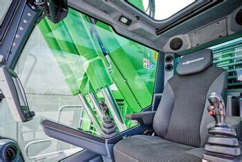 Wnętrze kabiny Maxcab żurawia Sennebogen 683 E z widokiem na elementy sterujące i monitory