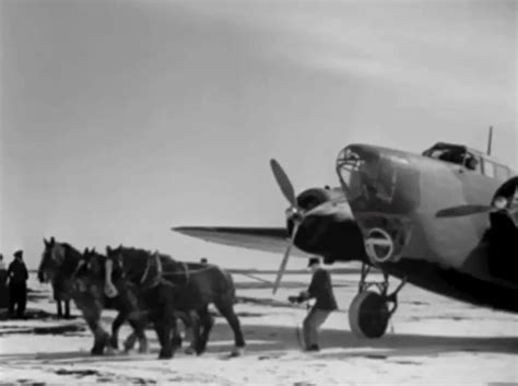 Historical photo of an early aircraft being towed by humans or horses