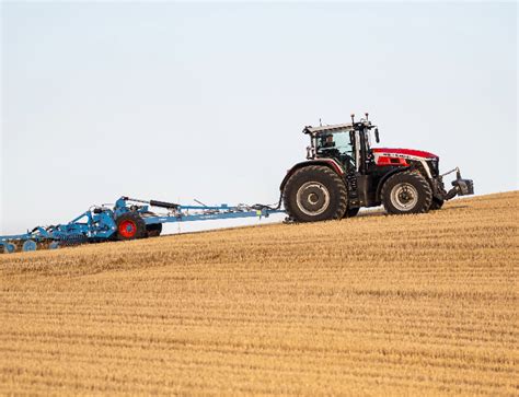 Tematyczne zdjęcie kombajnu zbożowego Massey Ferguson w trakcie pracy na polu