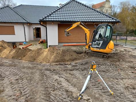 Zdjęcie minikoparki pracującej na placu budowy przy wykonywaniu wykopów