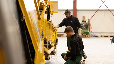 Technik serwisowy JCB podłączający laptop do maszyny budowlanej