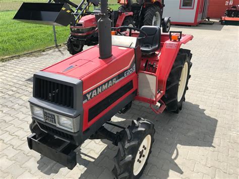 Traktor Yanmar F20D z zamontowanym turem na tle wiejskiego krajobrazu