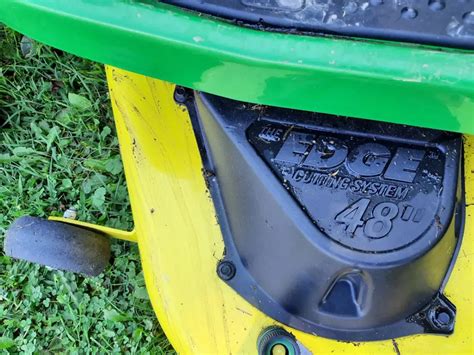 Panel sterowania i siedzenie John Deere D140 z widocznym uchwytem na kubek