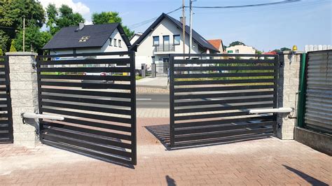 Samochód policyjny (suka) stoi przed bramą posesji