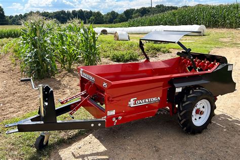 Technical drawing or infographic showing the dimensions and load capacity of a small single-axle manure spreader