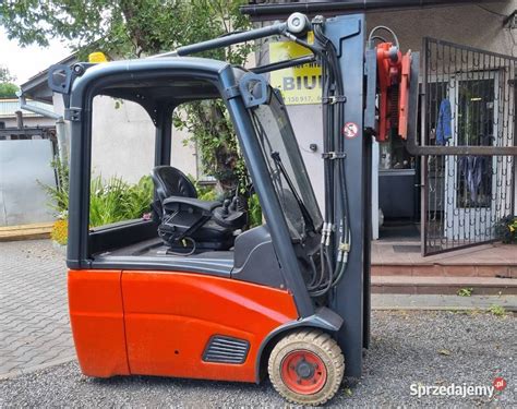 Elektryczny wózek widłowy Linde E20 w pracy w magazynie, z widoczną kompaktową konstrukcją i sprawnością manewrowania.