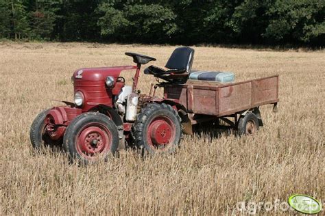Fotografia przedstawiająca historyczny ciągnik Dzik 1 podczas prac rolniczych