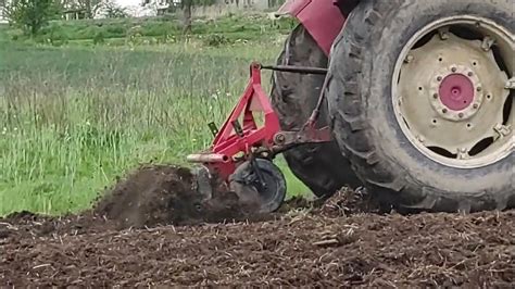 Glebogryzarka w akcji na polu z zaznaczoną strzałką pokazującą kierunek biegu wstecznego