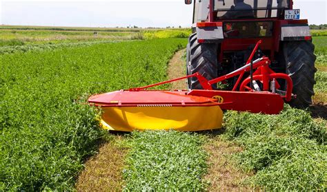 Thematic photo of a drum mower in action in a field