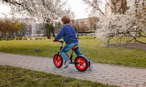 Chłopiec jeżdżący na rowerku biegowym na świeżym powietrzu