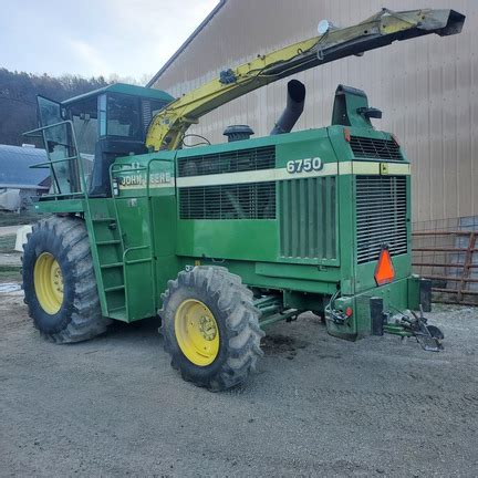 Zdjęcie przedstawiające sieczkarnię samobieżną John Deere 6750 w trakcie pracy w polu
