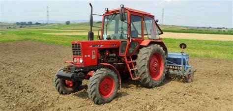 zdjęcie ciągnika MTZ-82 w akcji, np. w polu lub z ładowaczem