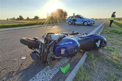 Motocyklista z widocznymi otarciami po upadku na asfalcie